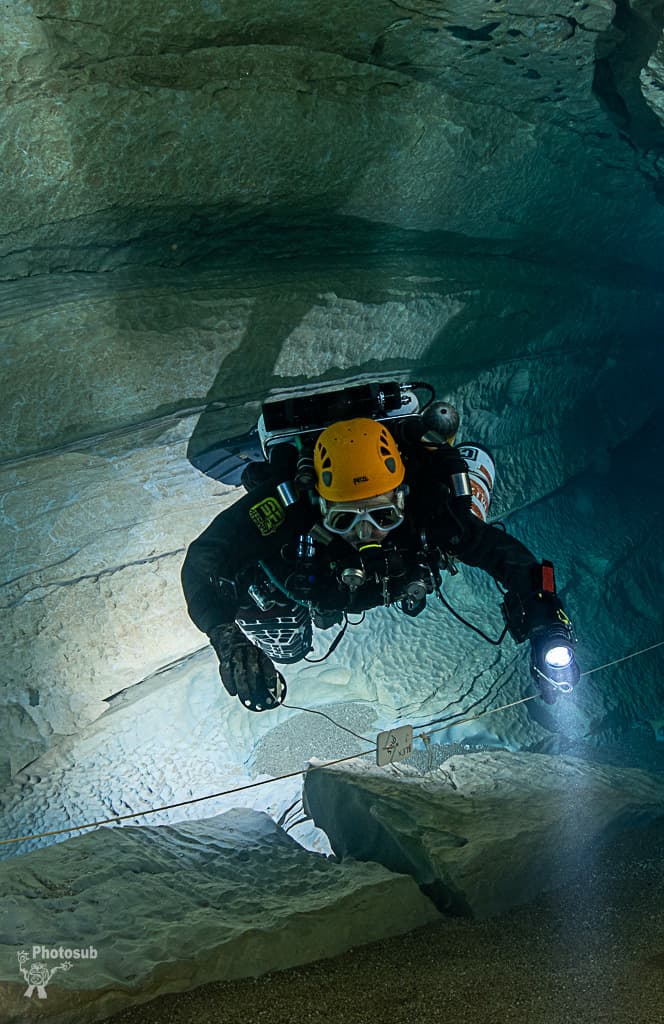 Diver approaching a REM navigation reference marker on the guideline in a narrow cave passage
